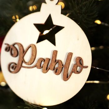 Detalle del adorno de Navidad con motivo estrella Personalizado con acabado en madera clara y nombre en madera oscura