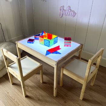 Mesa de luz Montessori con sillas iluminada con jueguetes