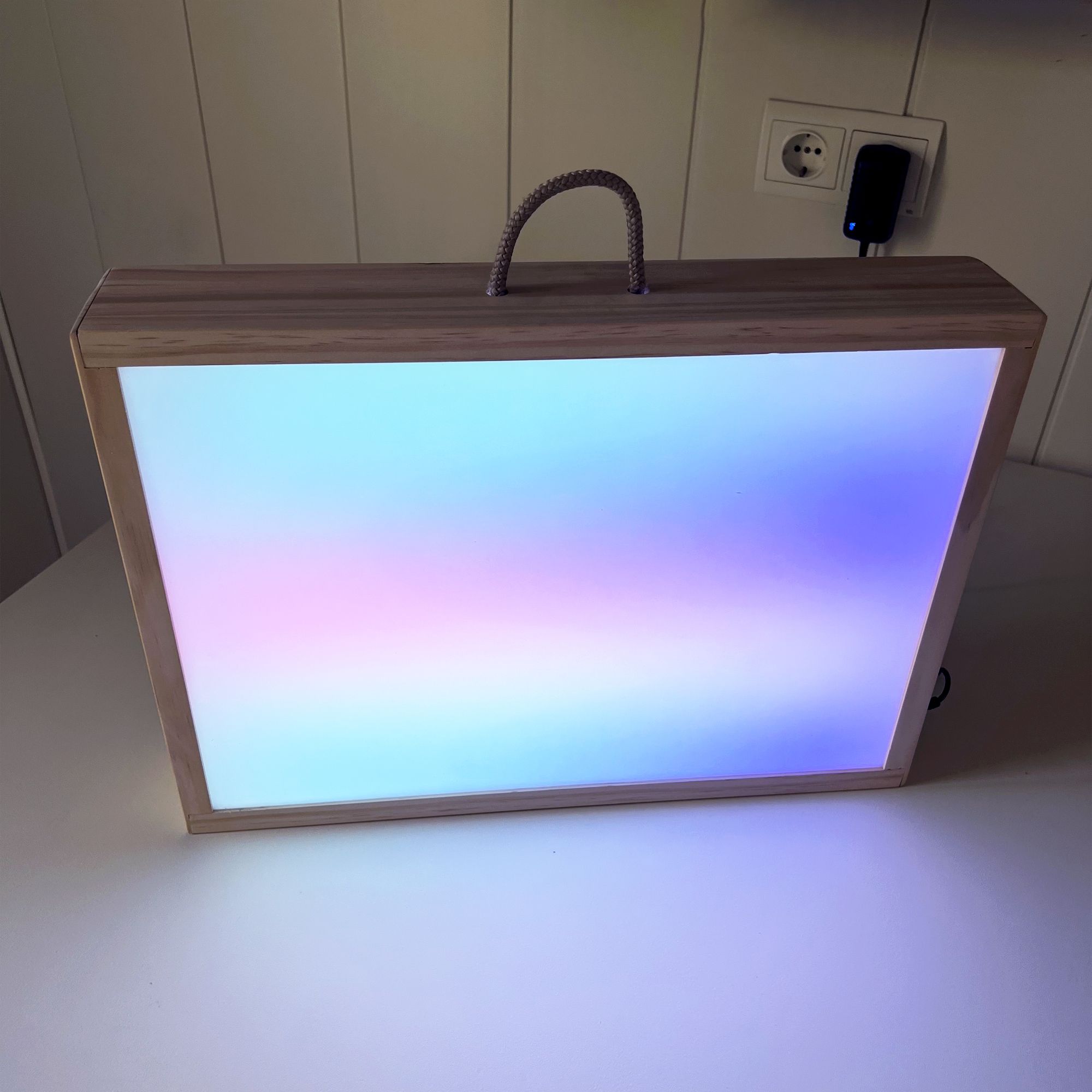 Caja de luz Montessori en funcionamiento mostrando un degradado de colores