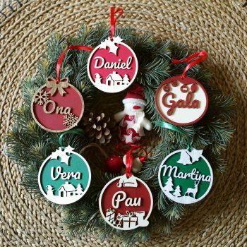 Grupo de bolas de Navidad personalizadas en relieve de distintos colores y motivos sobre un fondo navideño